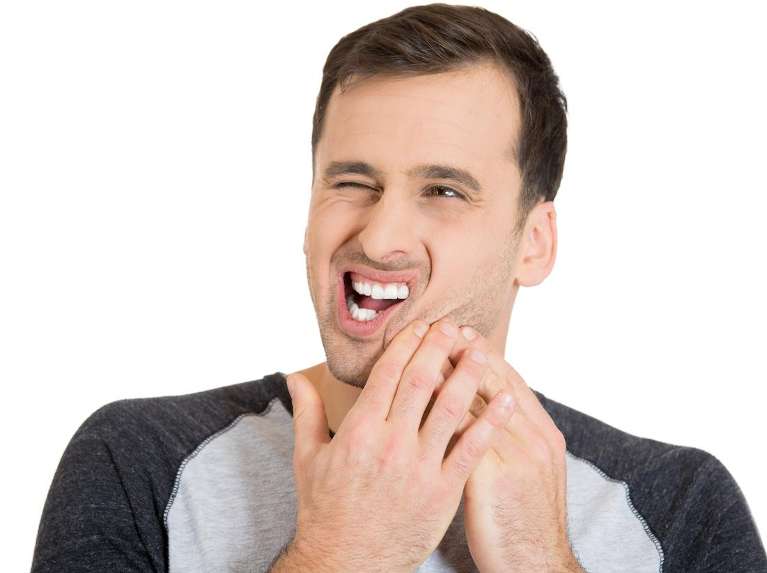 A Man holding his jaw due to a toothache in Surf City, NC
