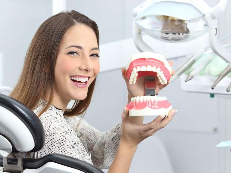 A patient with a dental model in Surf City Dental