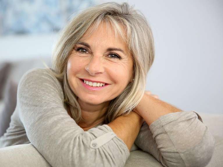 A woman smiling after getting a dry mouth treatment in Surf City, NC