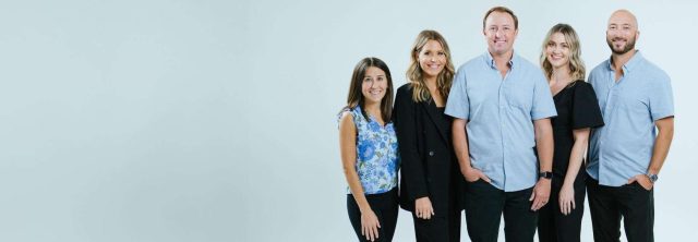 Dental care team at Surf City Dental, smiling and standing together, promoting a welcoming environment for patients experiencing dental anxiety.