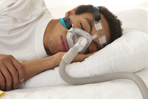 Person sleeping with CPAP mask for sleep apnea treatment, demonstrating effective airway management and compliance with therapy.